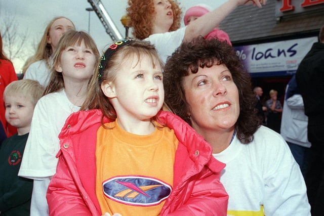 Tesco cashier Linda Simpson and her daughter Lauren Simpson, aged seven, watch the 999 yellow balloons float away into the sky in 2000