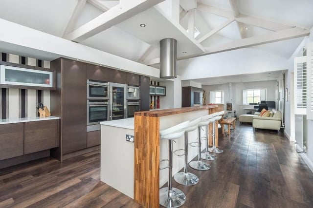 "Within the kitchen, the property remain retained some of its original features with pitched ceiling and exposed roof trusses above the sleek and contemporary fitted units which also incorporates a central island, breakfasting area and an abundance of granite, preparation and work tops."