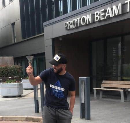 Jacob Whitehead rings a bell outside Proton Beam Therapy Centre in Manchester to mark the end of the first phase of his treatment.