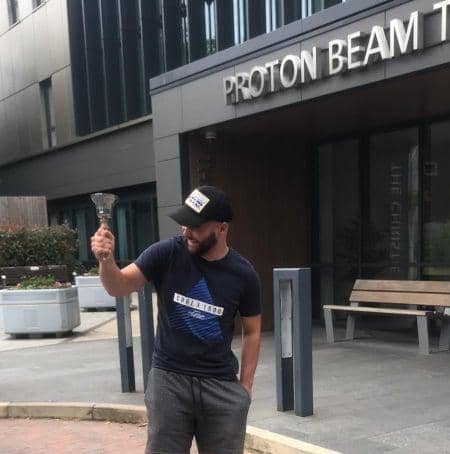 Jacob Whitehead rings a bell outside Proton Beam Therapy Centre in Manchester to mark the end of the first phase of his treatment.