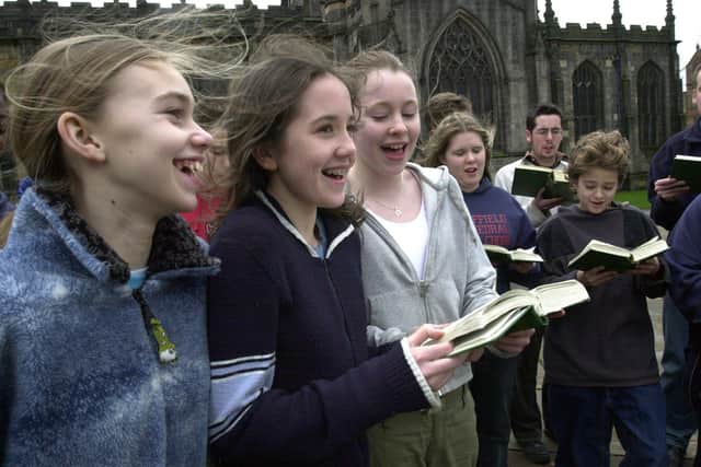 Cathedral choir members sing outside Sheffield Cathedral.