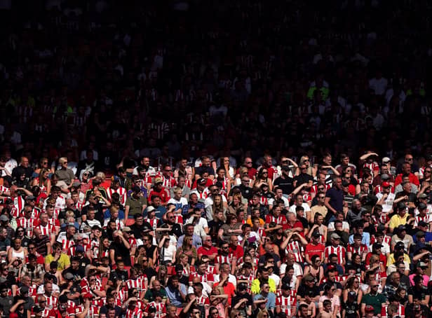<p>Sheffield United fans in the stands shield their eyes from the sun during the Sky Bet Championship play-off semi-final, first leg match at Bramall Lane</p>