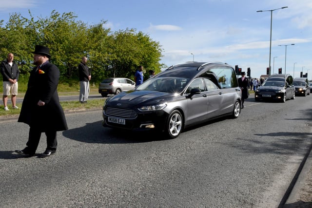 The funeral procession makes its way down John Reid Road