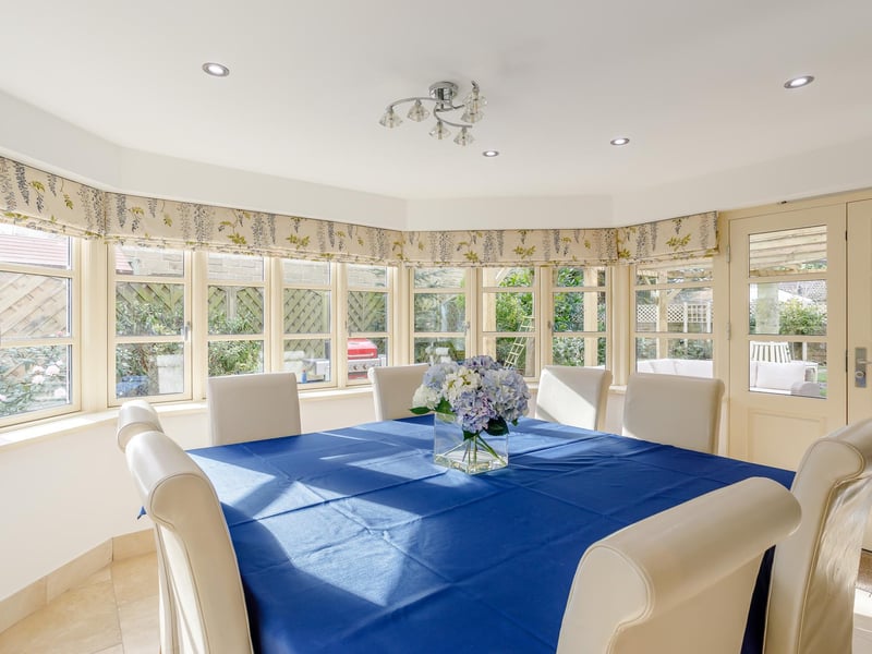 The dining area natural light streaming in through multiple windows and French doors to the rear garden