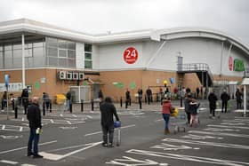 Shoppers queue using social distancing outside an Asda supermarket (Photo by OLI SCARFF/AFP via Getty Images)