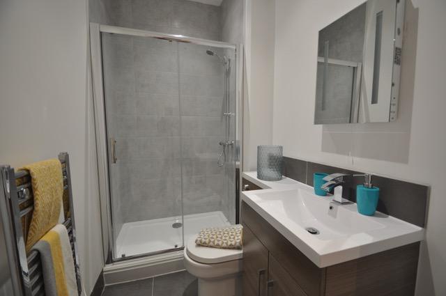 A clean and well decorated bathroom, with a basin, w/c, shower and radiator - as apartment bathrooms go this is pleasant.