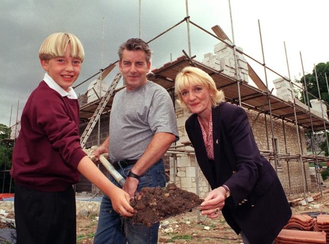 Builder Bill Stewart outside his new home which he was working on in 1999. His son Alistair and wife Vivviene also photographed.