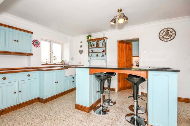 The traditional kitchen features an island, an alcove with feature brick and old beams, and a fully-working Aga. There is also a Belfast sink and a mixture of granite and wooden worktops. Nearby are a laundry room and a utility room.