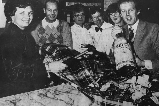 A gallon bottle at the Fourways in Kirkcaldy was smashed open to boost the coffers of two local charities - the Bone Marrow Appeal Fund and the Fourways' old folk.
Proprietors Lionel and Kathleen King are seen with Bells representative, Bill Hogg, plus members of staff.