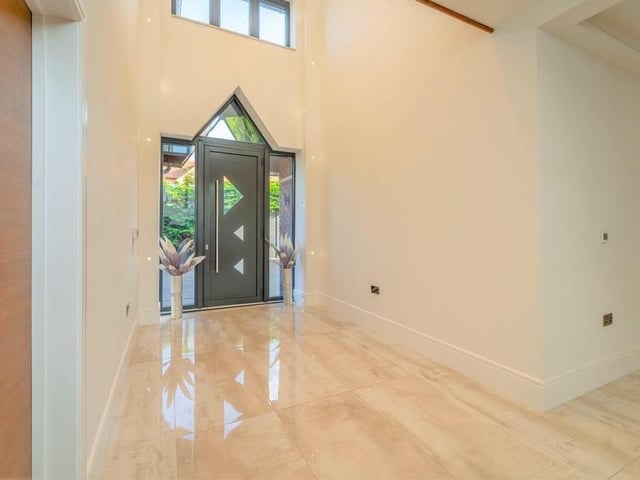 The property was designed by the award-winning firm, Greenwood Architects. That becomes apparent as soon as you enter this elegant hall, which has a double-height ceiling and leads to several rooms on the ground floor, including the dining room.