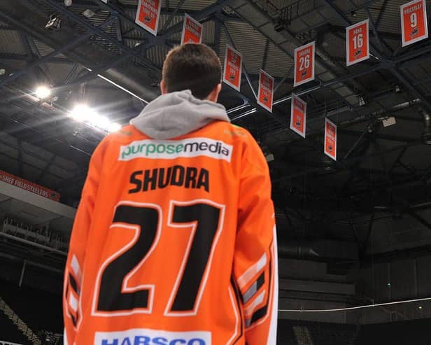 A young Cole Shudra admires his dad's number in the rafters