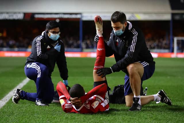 Rhian Brewster of Sheffield United is checked over by physio Steven Humphries after damaging his hamstring: David Klein / Sportimage