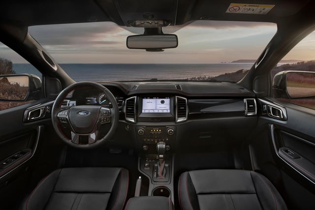 The interior is equipped with full Ebony leather seats with red embroidery and matching stitching across the steering wheel, seats, instrument panel and key touchpoints throughout the cabin. Black floor mats are also standard and contrast with bespoke red-illuminated sill plates.