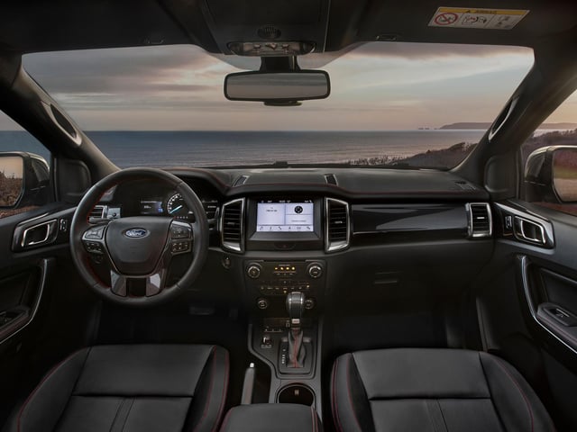 The interior is equipped with full Ebony leather seats with red embroidery and matching stitching across the steering wheel, seats, instrument panel and key touchpoints throughout the cabin. Black floor mats are also standard and contrast with bespoke red-illuminated sill plates.