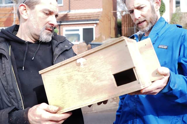 Jan Bullet and Rob Kenning (right) looking at a swift box before installation