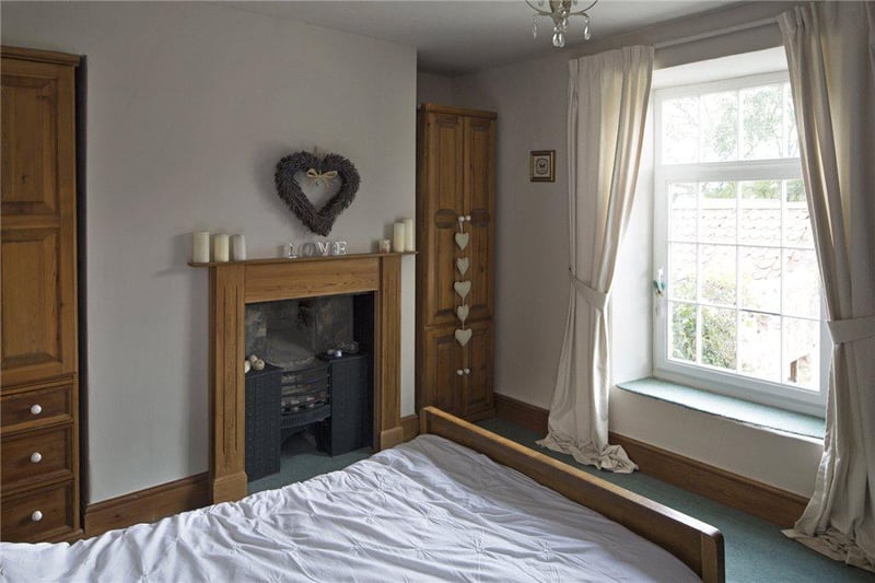 The bedroom features a pine fire surround with inset decorative dog grate.