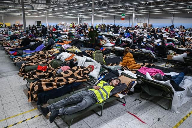 PRZEMYSL, POLAND - MARCH 08: People who fled the war in Ukraine rest inside a temporary refugee shelter that was an abandoned TESCO supermarket after being transported from the Polish Ukrainian border on March 08, 2022 in Przemysl, Poland. Over one million people have arrived in Poland from Ukraine since the Russian invasion of February 24, and while many are now living with relatives who live and work in Poland, others are journeying onward to other countries in Europe. (Photo by Omar Marques/Getty Images)