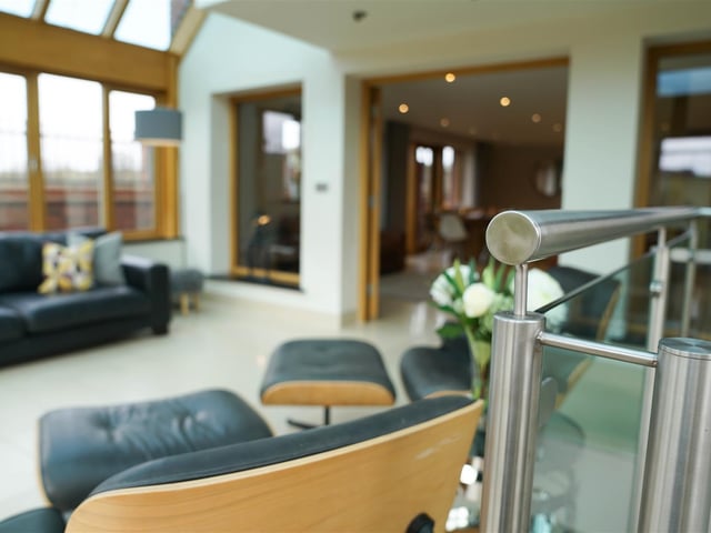 The bright double-height orangery has a staircase which leads to a gym/ games room.
