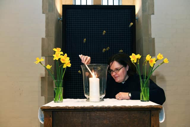 The Very Revd Abi Thompson Dean of Sheffield lights a candle in front of the Wall of Reflection at Sheffield Cathedral.
11th March 2022.
Picture : Jonathan Gawthorpe