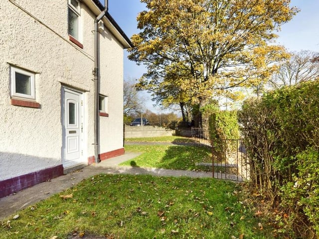 Front-side garden - Hedge enclosed with wrought iron access gates, laid to lawn with raised flower bed, paved path and hard standing; access gate opening into the rear garden.