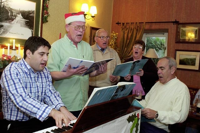 Organist Andrew Durdey and, in his Santa hat, landlord of the Wharncliffe Arms, Roger Walton, with some of the pubs regulars singing Christmas Carols on Sunday, December 8, 2002