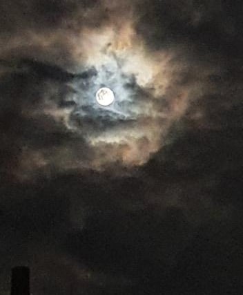 Tuesday night's supermoon peeks through the clouds in Hampshire