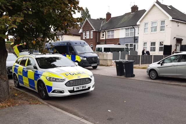 A large black police van was parked outside a house on Beck Street,  Shiregreen, with a marked police patrol car nearby. And across the street, a police dogs van was stopped, with its boot open.