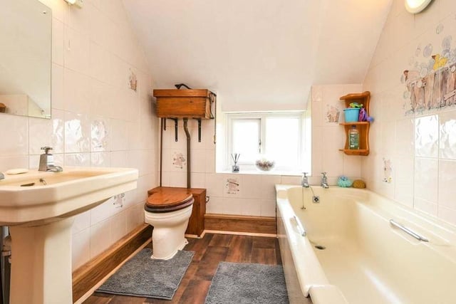 At the back of the house, on the first floor, is this family bathroom. A three-piece suite consists of a panelled bath, wash hand basin, a pull-chain WC, partly tiled walls and a uPVC double-glazed window.