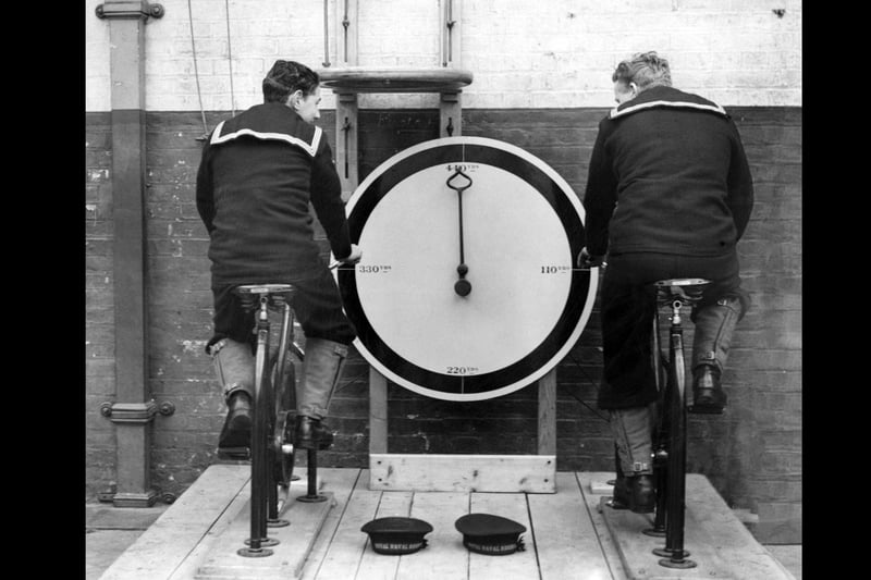 17th December 1936:  Two recruits at the Royal Navy barracks at Portsmouth, exercising on the new stationary cycles.  (Photo by Fox Photos/Getty Images)