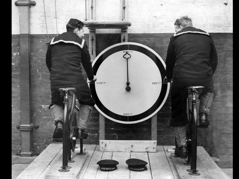 17th December 1936: Two recruits at the Royal Navy barracks at Portsmouth, exercising on the new stationary cycles. (Photo by Fox Photos/Getty Images)
