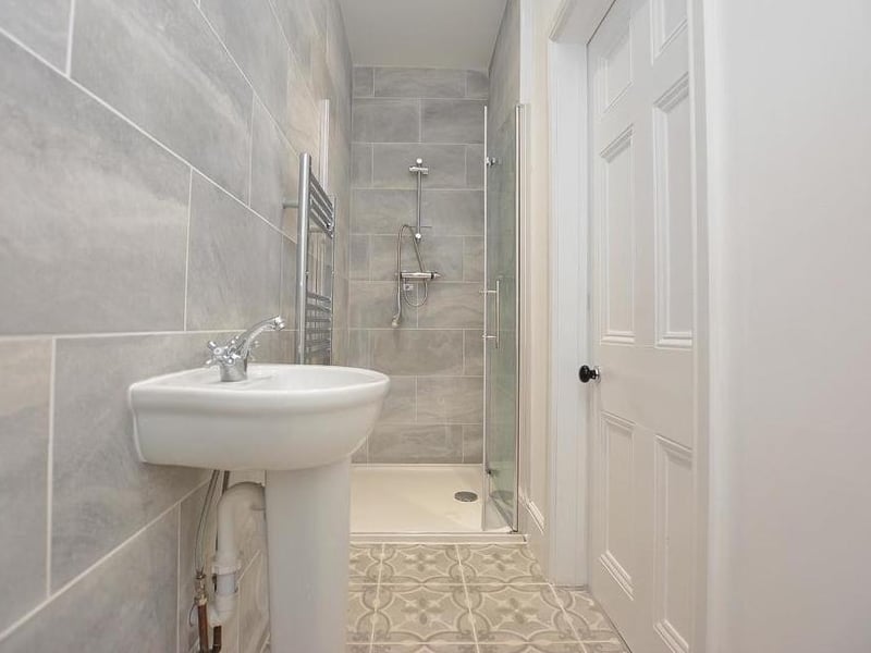 The first of two en-suite shower rooms, complete with a modern three-piece suite, comprising walk-in shower, wash hand-basin and low-flush WC. There is also a heated towel-rail, ceiling spotlights, tiled floor and extractor fan.