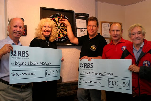 Proceeds from a charity darts marathon which took place at the Pack Horse in Chapel-en-le-Frith in 2009 being presented to Nick Pilling of Blythe House Hospice and Peter Chambers and John Mottram of Kinder Mountain rescue receive donations from Sharon Cox and Nick Ratcliffe