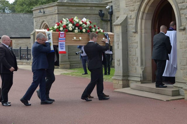 England and Leeds United scarves were draped over his coffin as it was carried into the crematorium.