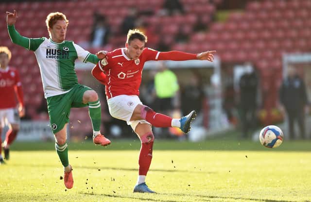 BARNSLEY, ENGLAND - FEBRUARY 27: Cauley Woodrow of Barnsley shoots at goal during the Sky Bet Championship match between Barnsley and Millwall at Oakwell Stadium on February 27, 2021 in Barnsley, England. Sporting stadiums around the UK remain under strict restrictions due to the Coronavirus Pandemic as Government social distancing laws prohibit fans inside venues resulting in games being played behind closed doors. (Photo by Nathan Stirk/Getty Images)