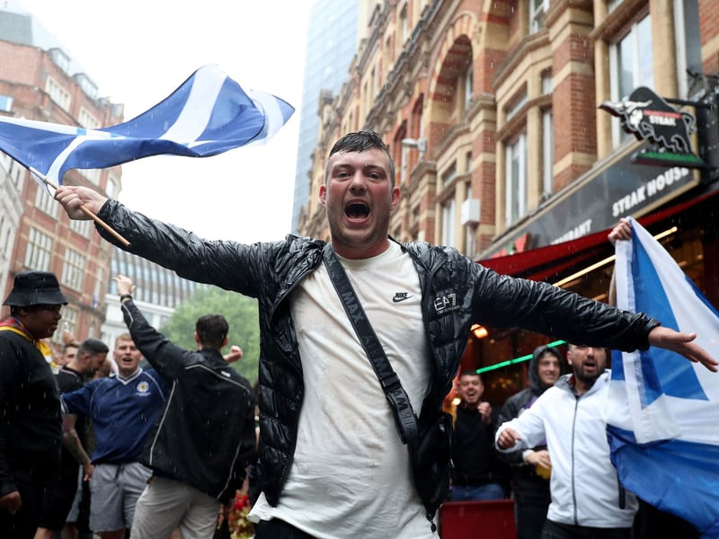 One man waves his saltire with pride as another is seen in the background (Photo: Kieran Cleeves/PA Wire).