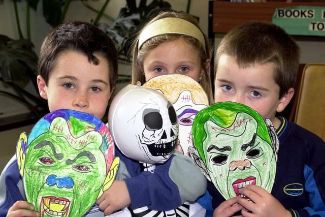 Tom McMahon aged seven, Danielle Taylor aged eight and Matthew Guy aged six with masks they made in Sprotbrough Library in 2002.