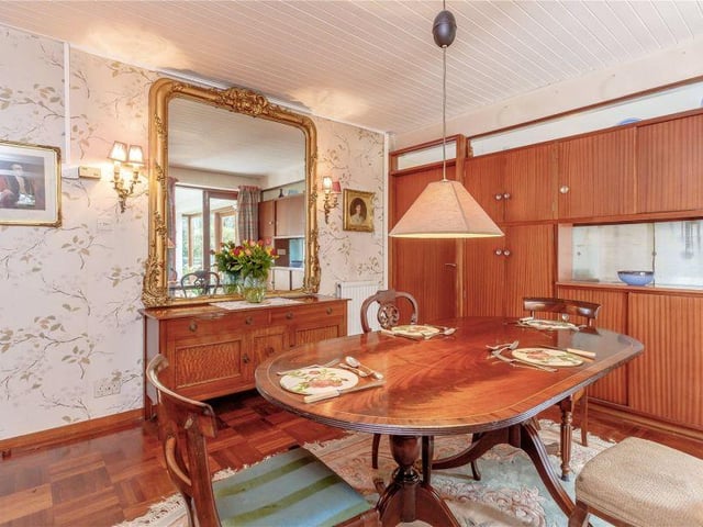 The dining room, with its parquet floor and folding doors that open into the hall, offers a versatile use of space