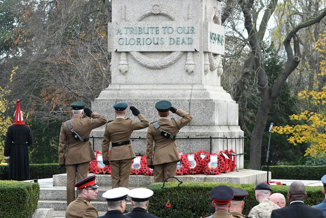 Soldiers saluting the fallen after laying a wreath.