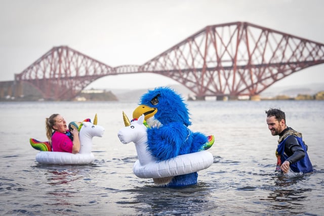 People take part in a New Year's Day dip in front of the Forth Bridge at South Queensferry, Edinburgh. Covid restrictions across Scotland have meant that many new year traditions including the official annual Loony Dook have been cancelled. Picture date: Saturday January 1, 2022. PA Photo. Photo credit: Jane Barlow/PA Wire