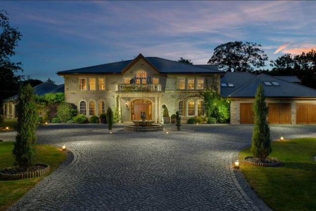 Set behind electronic gates, a long granite driveway leads up to the entrance, with landscaped gardens and hedged boundaries for privacy. 
There is parking for several vehicles and garage space. Image by Rightmove.