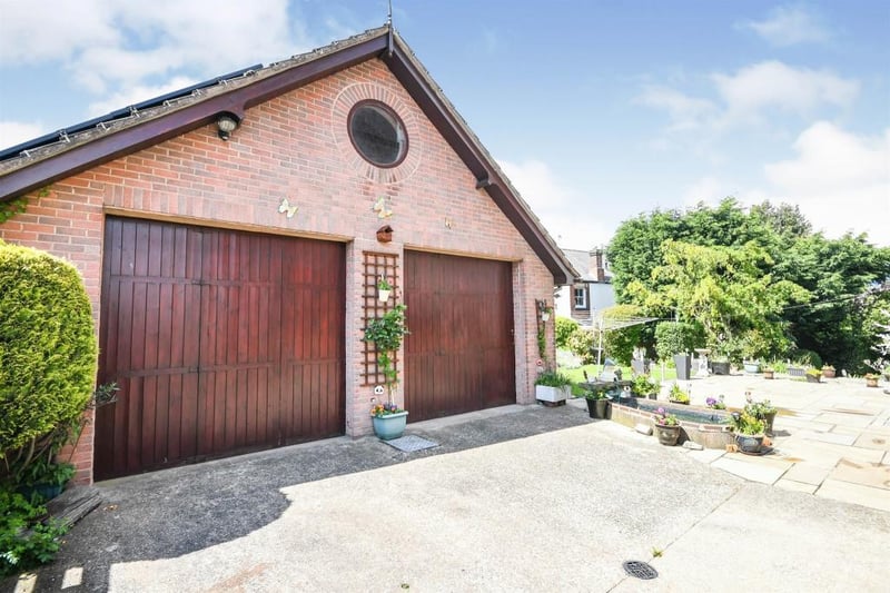 The property boasts a double garage fitted with two sliding doors, power and lighting, with a side-facing window and door.