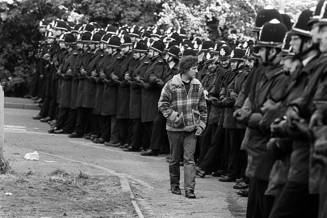 A striking miner 'inspects' a long line of police officers outiside the Orgreave Coking plant in 1984