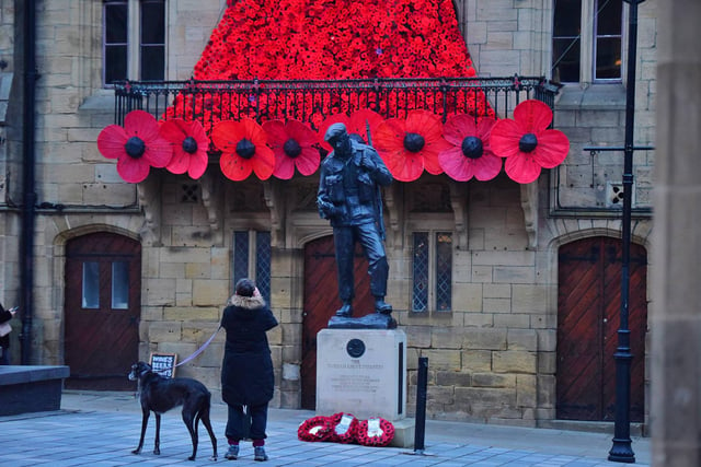 A dog walker takes a picture of the Durham City Durham Light Infantry memorial and its colourful backdrop.