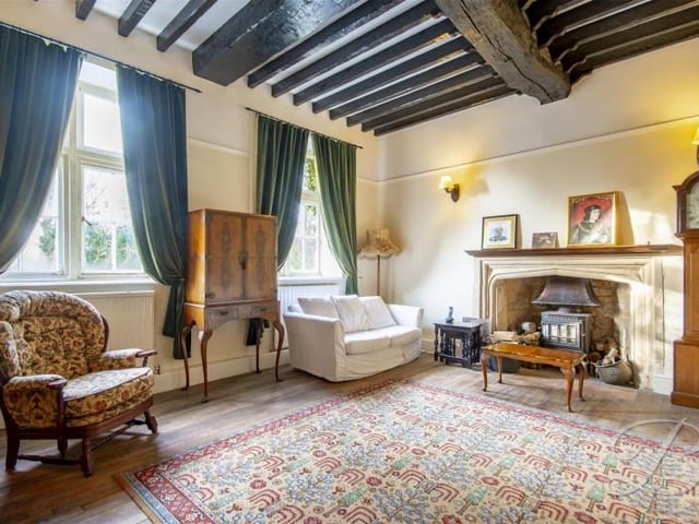 The first living room has a lovely fireplace, fantastic beams and two windows.