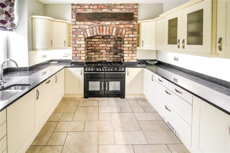 Stylishly refitted with a range of cream painted wall and base level units with black granite work surfaces.