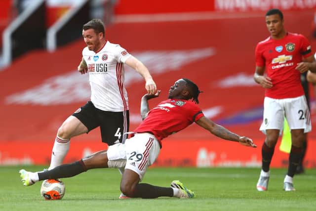 John Fleck of Sheffield United battles for possession with Aaron Wan-Bissaka of Manchester United during the Premier League match between Manchester United and Sheffield United at Old Trafford on June 24, 2020 in Manchester, England. (Photo by Michael Steele/Getty Images)