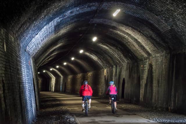 Inside Chee Tor Tunnel as cyclists make their way along the trail