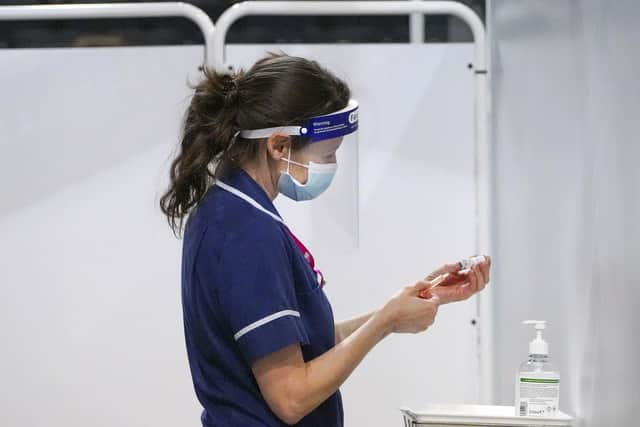A nurse prepares a vaccination at Sheffield Arena