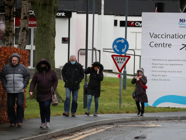 People walking by a Vaccination Centre sign at the Royal Highland Show ground in Edinburgh.