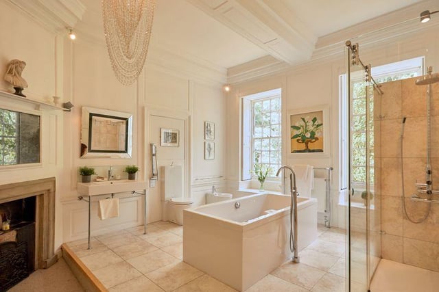 The property benefits from two bathrooms, with this impressive main bathroom benefitting from marble effect tiled floors, a walk-in shower, central bathtub and an original fireplace.